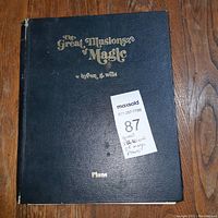 Front cover of black hardcover book titled 'The Great Illusions of Magic' by T. Nelson Downs and C Wells with gold embossed lettering and a MaxSold sticker.