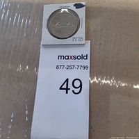 Photo of the silver coin in a holder showing the year 1978 and '49' sticker below