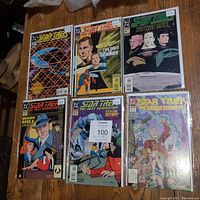 Image of six Star Trek comic books laid out on a surface, showing full covers including titles and artwork.
