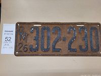 Front view of the vintage 1926 Ontario license plate showing embossed number 302-230 and rusted metal surface.