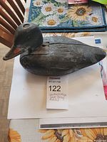 Top and side view of the wooden duck decoy showing red bill and loose head.