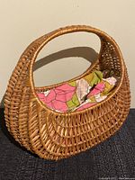 Side view of the woven wicker gondola basket purse showing the floral fabric lining inside.