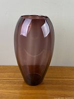 Front view of the amethyst purple glass tall vase with smooth surface and rounded shape.
