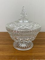 Front view of Early American cut glass candy dish showing decorative cut pattern, pedestal base, and pointed lid.