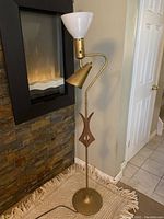 Full view of the retro floor lamp showing white top shade, brass directional moving light, and wooden accent on pole.