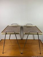 Front view of two identical retro accent tables with hairpin legs and wood grain tops stacked side by side