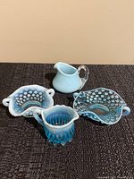 All four pieces shown together on dark fabric background.