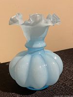 Front view of the vintage blue Fenton glass vase showing ruffled white-tipped rim and bulbous body.