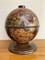 Closed view of vintage globe ice bucket showing antique map design on exterior and round base