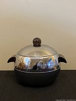 Front view of vintage aluminum ice bucket with polished upper section and wood knob lid