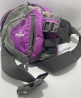 Full view of the purple and gray dog backpack showing adjustable straps, zippered compartments, and quick assist handle.