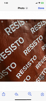 Close-up of the red Resisto membrane material with repeated white 'RESISTO' printed text on it.