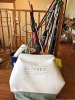 Full view of bundled cleaning tools including mops, vacuums, and laundry bag.