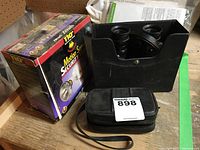 Motion sensor light in original box and small 10x25 binoculars in black leather case with wrist strap