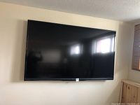 Front view of Sharp 70" flat screen TV mounted on wall