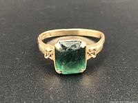 Front view of the 10Kt gold ring showing the green gemstone and decorative details.