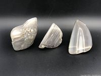 Three large agate rocks positioned side by side on a black background, showing their size, color, and natural banding features.
