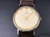 Front view of round Cimeqa watch with cream dial, gold markers, and brown leather strap.