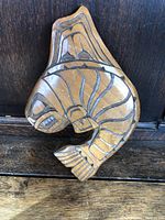 Front view of the carved wooden whale showing detailed black line etching and smooth finish.