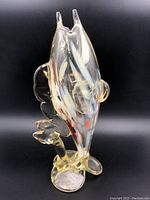 Front and side view of glass fish shaped vase showing clear translucent body with yellow tint and detailed fins