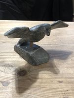 Front and side view of the Inuit carved stone bird on wooden surface