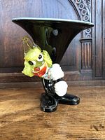 Front angle of Murano Glass Clown Vase showing clown's face, wide black flared top, and details of the figure holding the vase.
