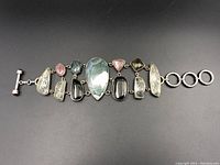 Full bracelet laid flat showing all gemstones and the toggle clasp with extension rings