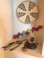 Overall view of Papago basket, thunderbolt stick, and other baskets with dream catcher on display