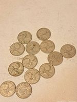 13 used Canadian silver quarter coins featuring caribou design laid flat on a surface, showing obverse sides.