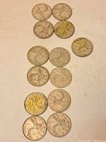 Top-down view of 13 Canada silver quarter coins showing caribou design with varying conditions and tarnish.