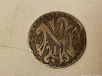 Engraved monogram side of the 1874 Peru silver coin showing detailed decorative engraving and scalloped border.