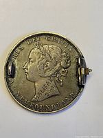 Obverse photo of the 19th century Newfoundland 50 cent coin showing Queen Victoria's profile and the inscription "Halifax 90-91" engraved below.