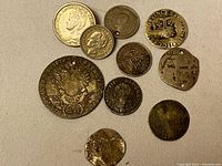 Overview of all 10 coins laid on fabric background