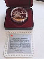 Opened presentation case displaying the silver proof coin in protective capsule and the Certificate of Authenticity card with bilingual information about the coin's historic significance and specifications.