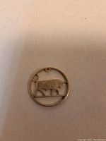 Top side of the pendant showing the bull shape cut from the Irish silver coin with visible detailing.