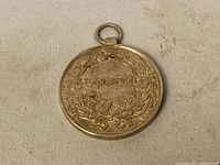 Photo of rear side of WWI-era Austrian silver merit medal with German inscription and laurel wreath