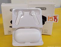 Photo showing two sets of white wireless earbuds with charging cases in front of their packaging boxes labeled TWS-Y18.