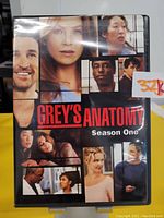 Front view of the Grey's Anatomy Season One DVD case showing the cover art with various character images in a collage and title text.