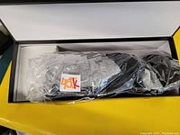Pair of black and grey heated socks inside a black and yellow box, sealed in clear plastic.