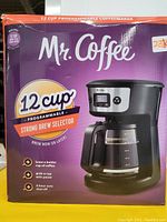 Front view of Mr. Coffee 12-cup programmable coffee maker box showing branding, model features including strong brew selector, programmable timer, and 12-cup capacity.