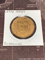 Front side of 1877 Jersey 1/12 Shilling coin showing shield with three lions and year 1877, labeled as twelfth of a shilling.