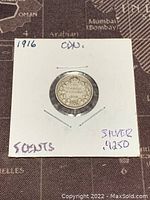 Back side of 1916 Canadian 5 cents silver coin in protective cardboard holder