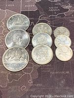 Canadian silver coins assortment 1961-1965 showing three silver dollars and various denominations.