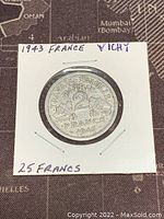 Obverse side of the 1943 Vichy French State 2 Francs coin mounted in holder, showing denomination and date.
