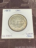Obverse side of the 1952 Canadian 50 cent silver coin showing the Canadian coat of arms and denomination.