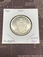 Obverse side showing Canadian coat of arms with inscription 'Canada 1966 50 Cents 80% Silver'. Held in a square coin holder with labels.