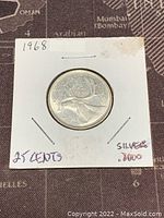Front side of the 1968 Canadian 25 cents silver coin showing the caribou and denomination details.