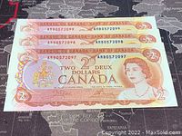 Three consecutive 1974 Canadian $2 banknotes showing front sides with Queen Elizabeth II portrait and serial numbers.