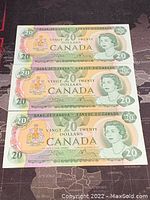 Three consecutive 1979 Canadian $20 bills laid flat, front face up showing Queen Elizabeth II portrait and the Canadian coat of arms.