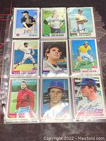 Image showing nine baseball cards in plastic sleeves with players from various teams, some cards show printed autographs.